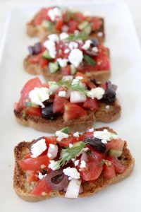 Paleo Greek Bruschetta from the Whole Smiths. A fresh twist on the classic using Simple Mills Artisan Bread Mix. Gluten and grain-free, paleo-friendly.