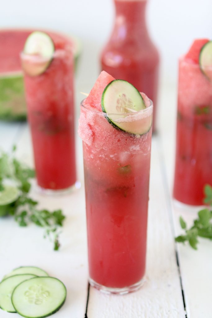 a refreshing refined sugar-free watermelon cooler with cucumber slices and lime in a tall glass