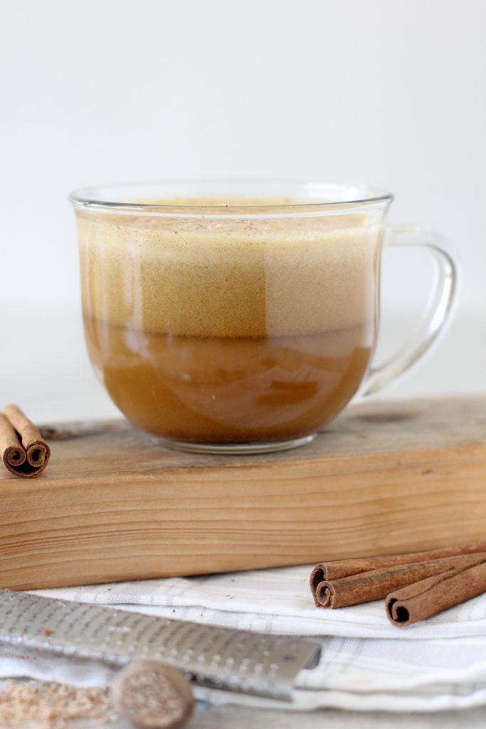 side view of a mug of paleo pumpkin spice latte with almond milk froth