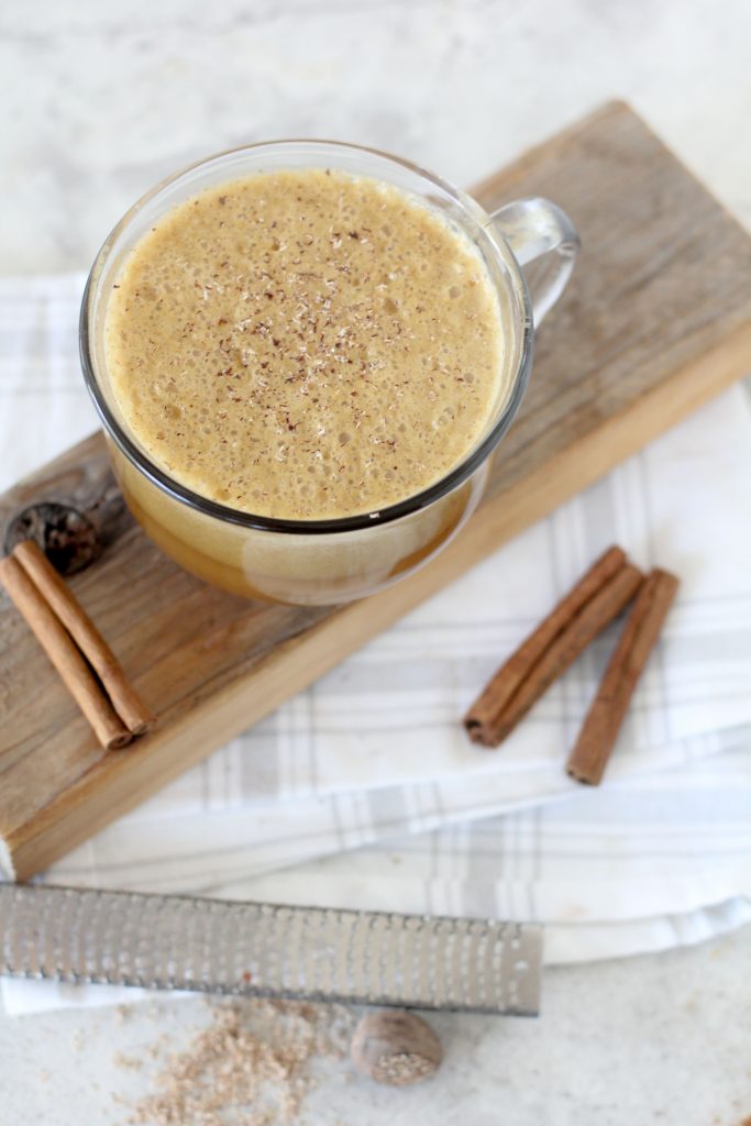 overhead shot of a mug of paleo pumpkin spice latte topped with almond milk froth