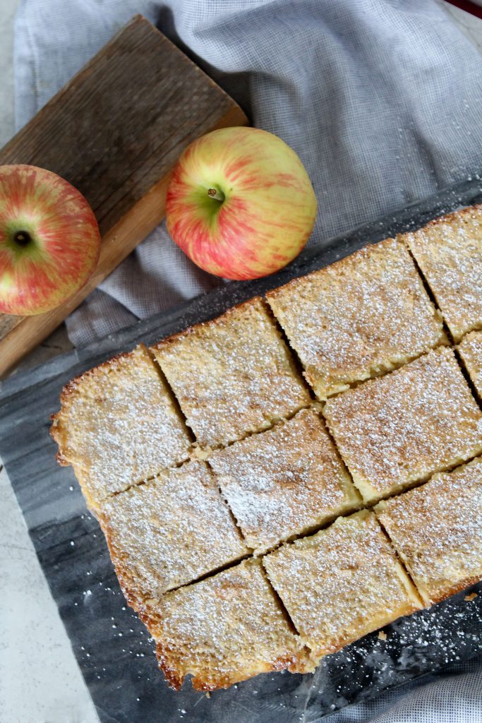 overhead shot of Gluten-Free Apple Bars with apple cider custard on a black stone cutting board 