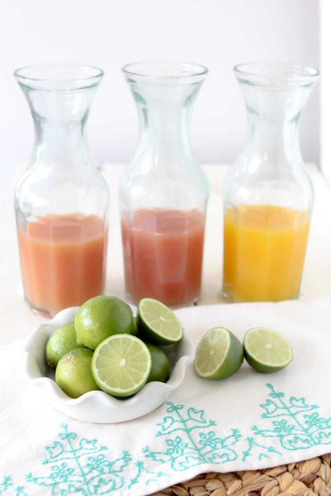 different fruit juices in glass bottles needed to make healthy margaritas
