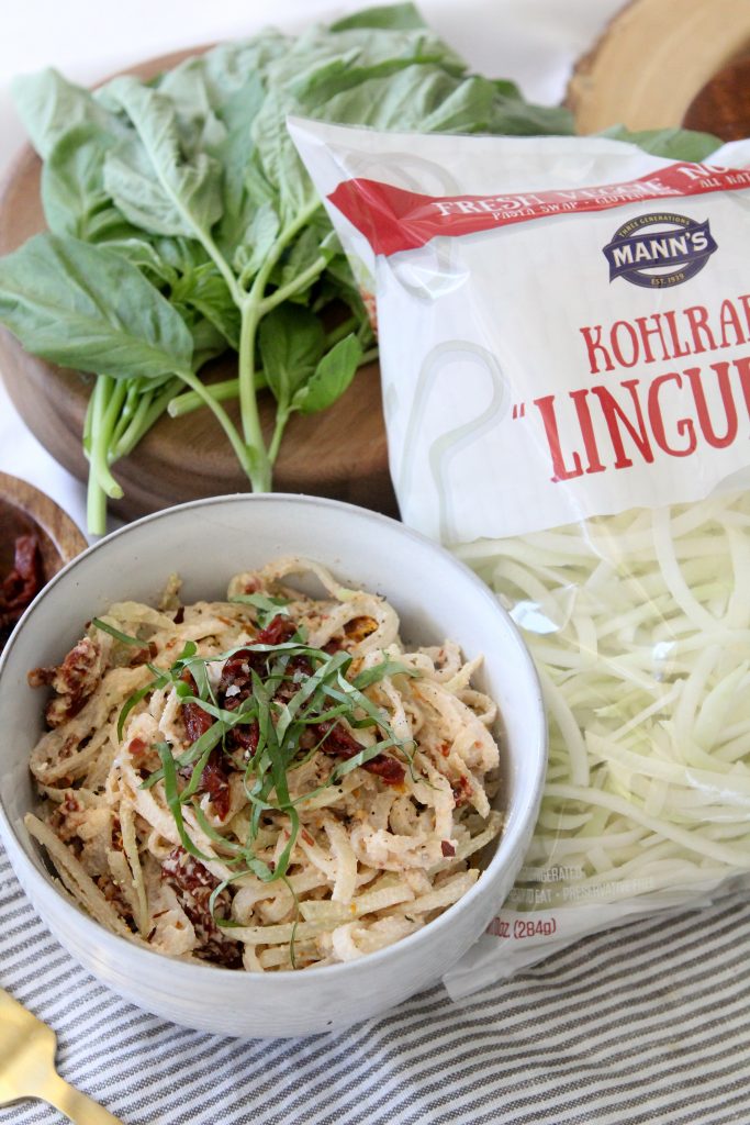 a bowl of easy Creamy Sun-Dried Tomato zoodles next to a bag or spiralized veggie noodles