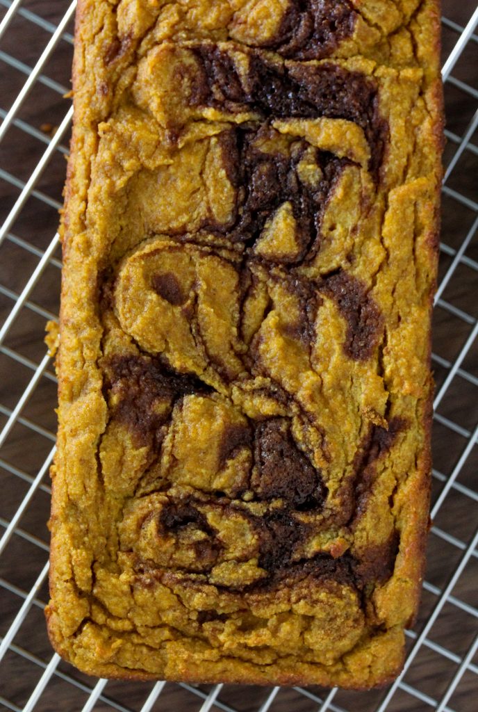 overhead shot of a loaf of Grain-Free Cinnamon Swirl Pumpkin Bread on a wire cooling rack 