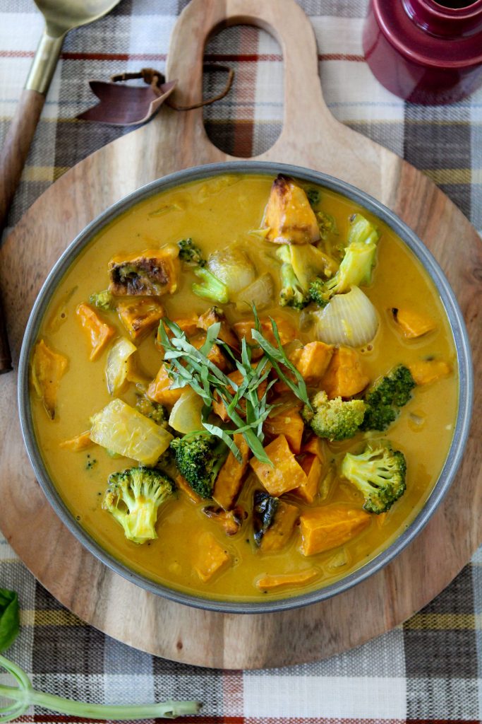 overhead shot of a bowl of vegan Pumpkin Curry garnished with chopped basil 