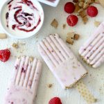 overhead shot of Raspberry Cheesecake Gluten-free Popsicles on a white table