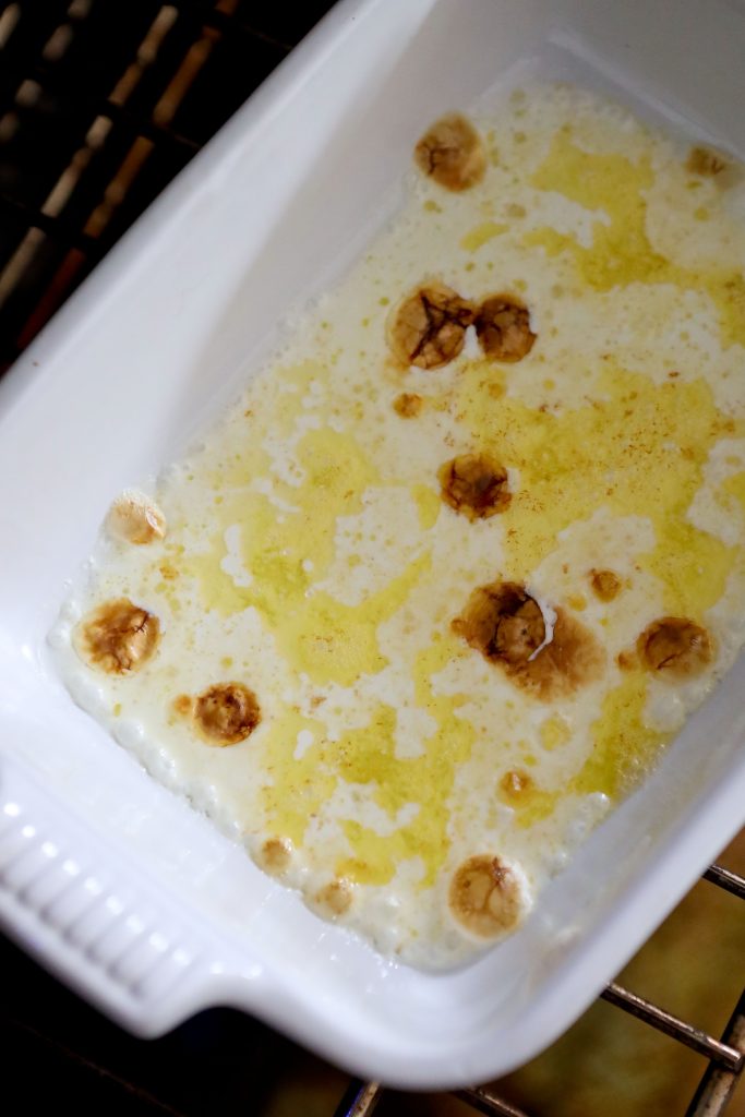 cream and butter browning under the broiler in a white casserole dish