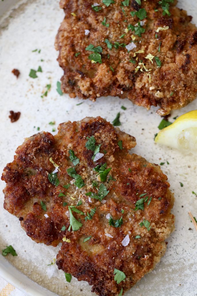 overhead shot of two paleo grain-free pork schnitzel placed on a plate