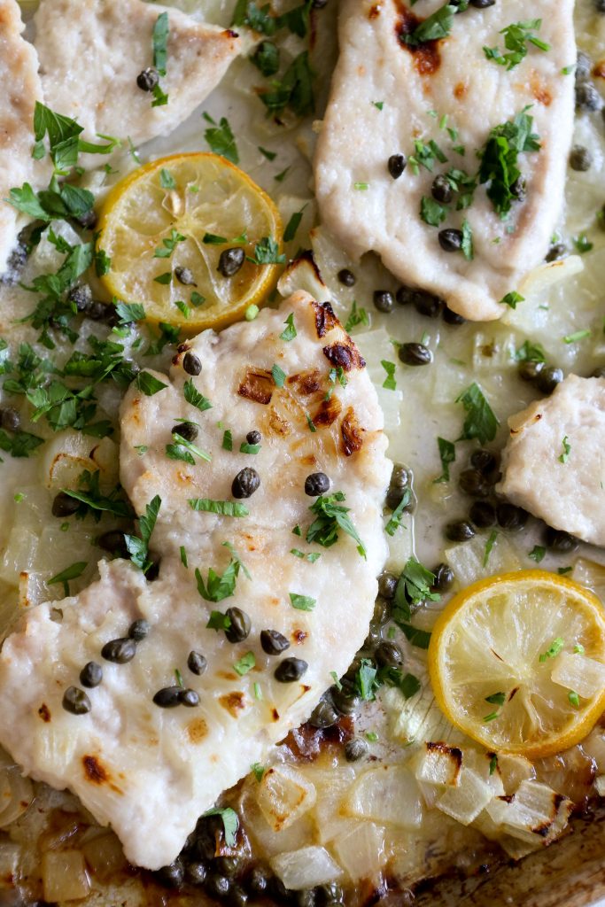 close-up overhead of chicken piccata on a sheet pan 