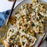 healthy chicken piccata with charred lemon slices on a big serving plate